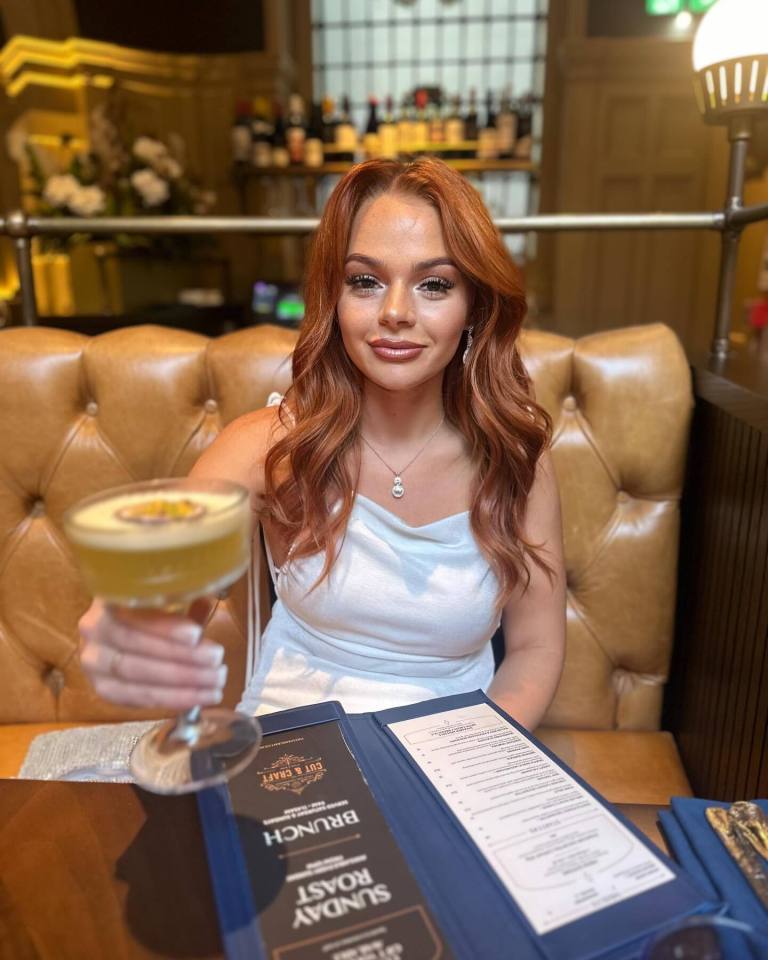 Woman holding a cocktail in a restaurant.