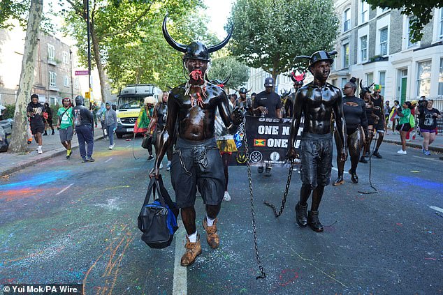 As part of the Jab-Jab tradition, participants march through the streets with chains