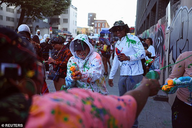 Partygoers spray each other with paint as the carnival gets underway at 6am