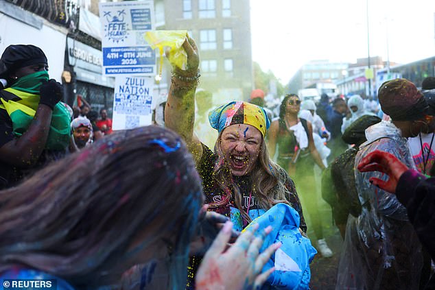 A woman is covered in paint and powder during the J'Ouvert celebrations