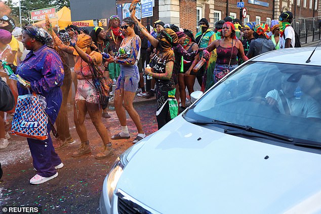 A driver tries to make his way through the crowds as J'Ouvert took over Notting Hill
