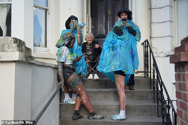 A local watches on from her doorway as the carnival got underway in flamboyant style