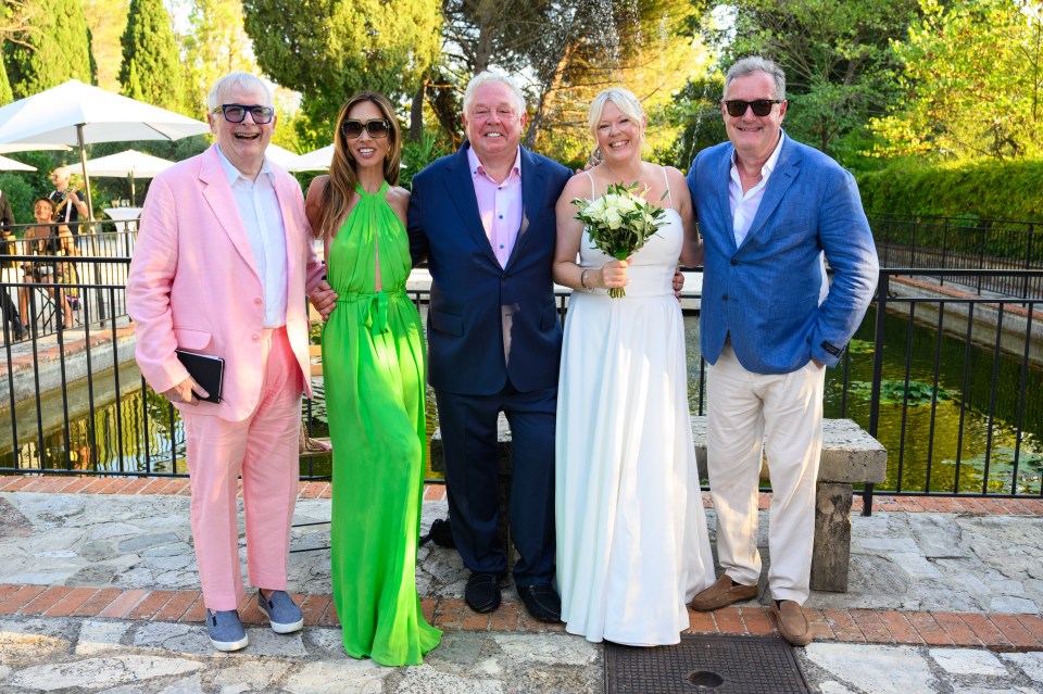Wedding guests, including Myleene Klass and Piers Morgan, posing for a photo with the bride and groom.