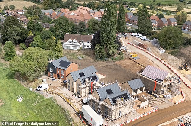 The huge house, which lies empty, is seen surrounded by newbuild homes