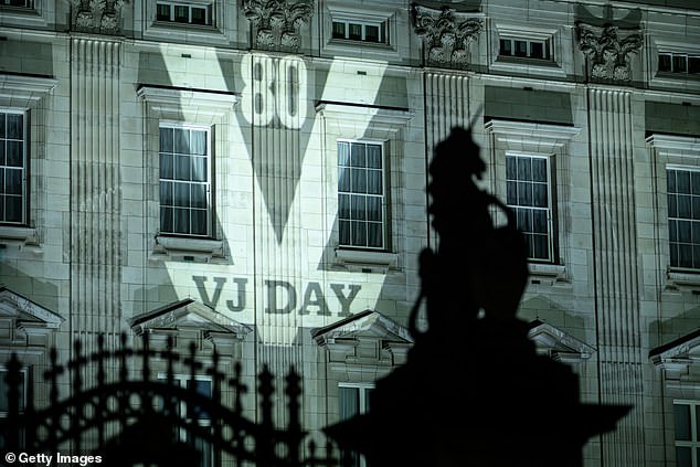 Projections reading "VJ DAY 80" are displayed on the exterior of Buckingham Palace on August 14