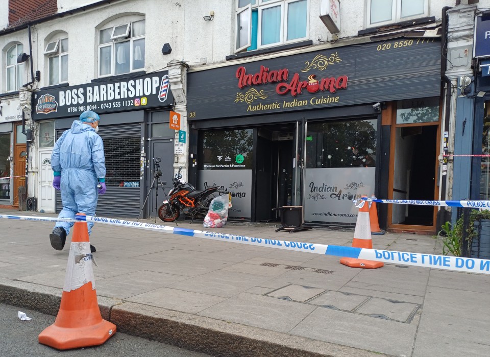 Forensic investigator at the scene of a suspected arson attack at an Indian restaurant.