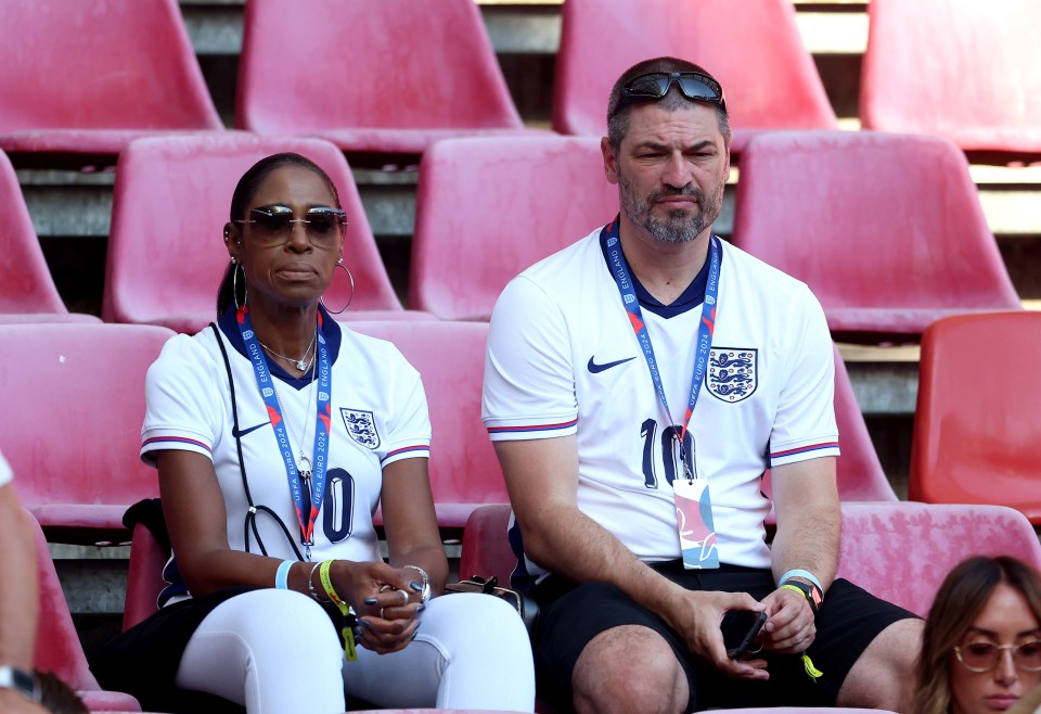 Jude Bellingham's parents in the stands at a soccer match.