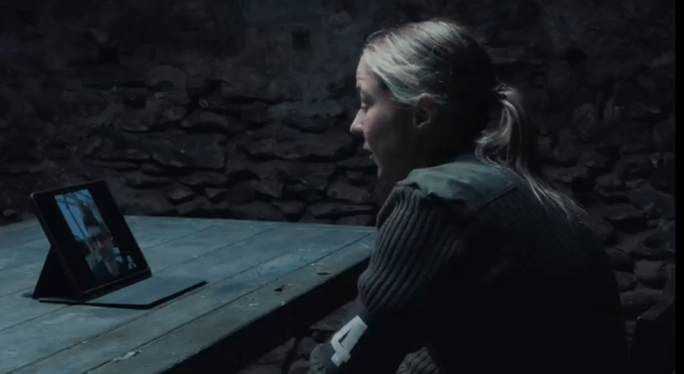 Woman on a video call in a dark room.