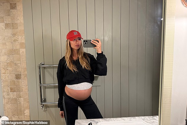 Sophie sported a casual look in one snap as she posed by the bathroom mirror to reveal her massive baby bump as her pregnancy progresses
