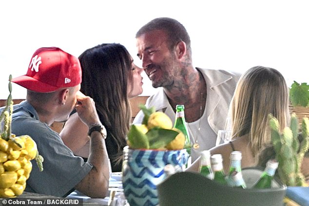 The fashion designer, 51, and her former professional footballer husband, 50, were spotted locking lips and wrapping their arms around each other as they dined at Lo Scoglio restaurant