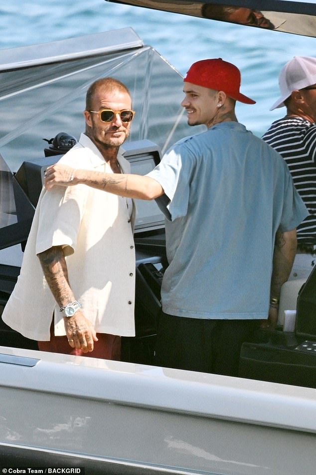 Romeo flashed a cheesey grin while stood with his father