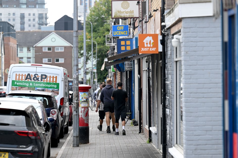 Street scene in Cardiff, Wales, showing pedestrians and shops.