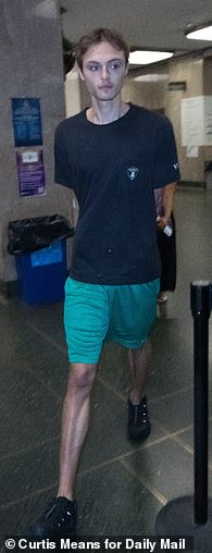 He wore a black T-shirt, green basketball shorts, and black sneakers