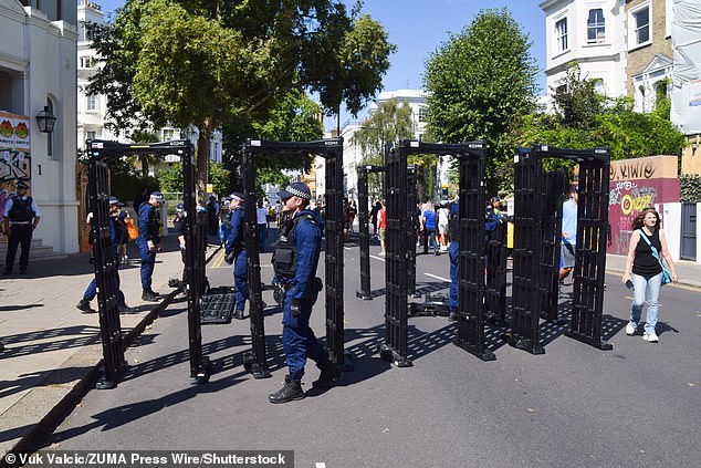 Police officers install knife arches on the opening day of Notting Hill Carnival 2025