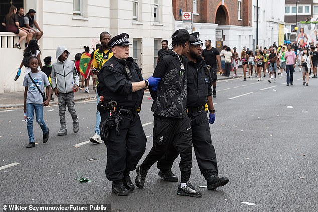 A man is led away by police at the street party on Sunday