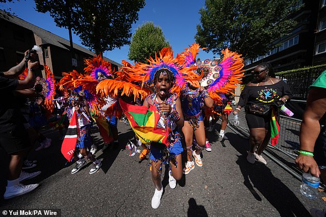 People taking part in the Children's Day Parade, part of the Notting Hill Carnival celebration in west London on Sunday, August 24