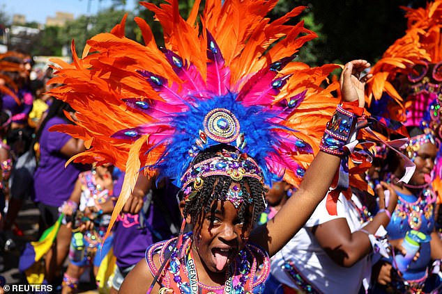 A child, wearing a headdress, gestures during at the Children's Day Parade