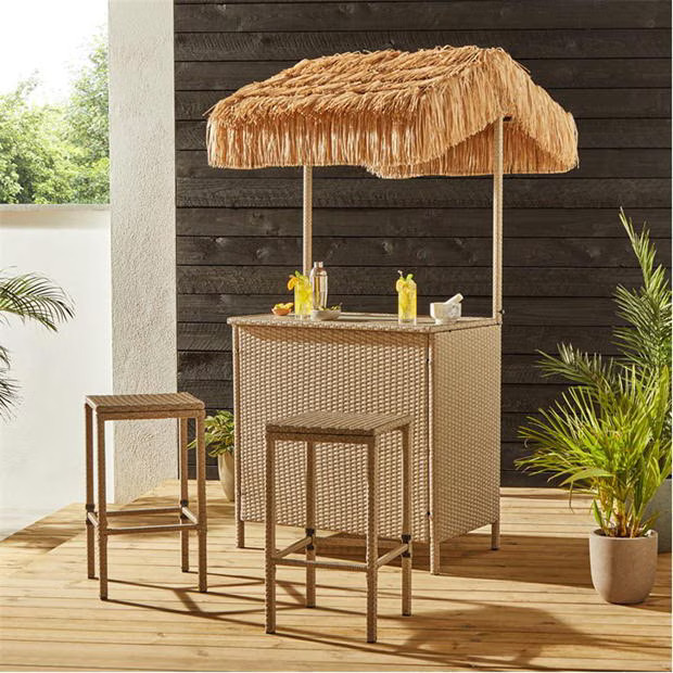 Outdoor wicker bar with thatched roof and two stools.