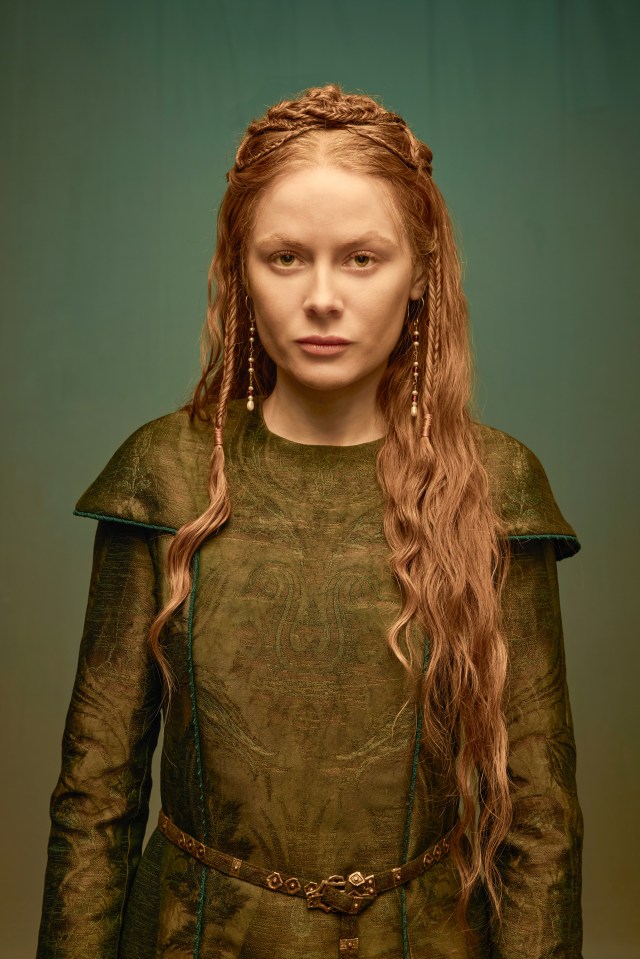 Portrait of Emily Beecham as Edith in a green medieval-style dress.