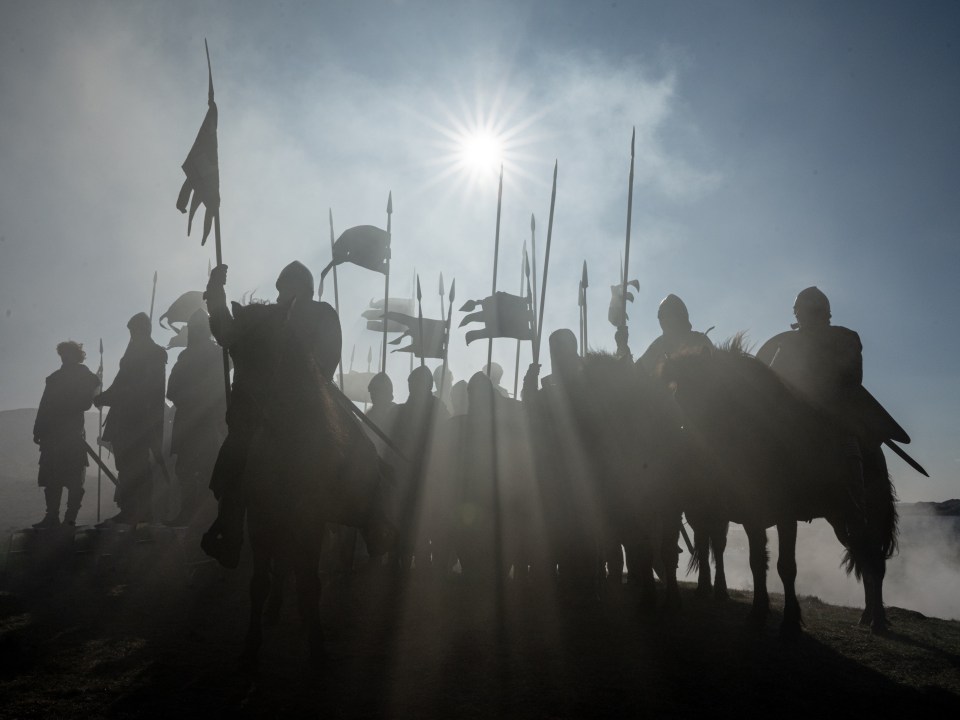 Silhouetted medieval soldiers on horseback.