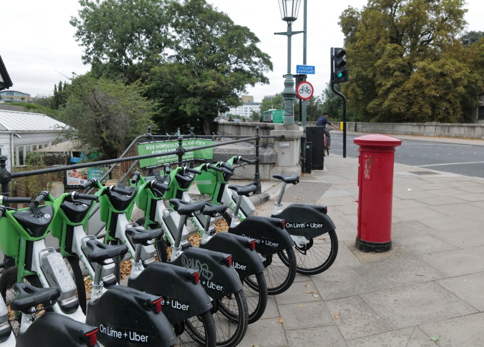 Lime bikes parked near a bridge.