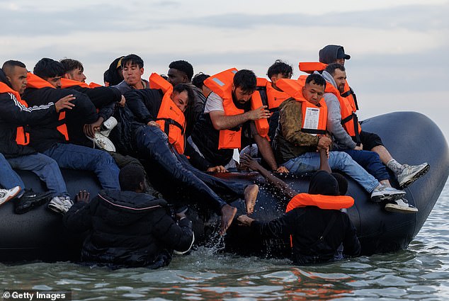 Around 50,000 small boats have arrived in the UK since Labour entered Government in July last year. Pictured: Migrant families climb on to a small boat at Gravelines, France, on August 12, 2025