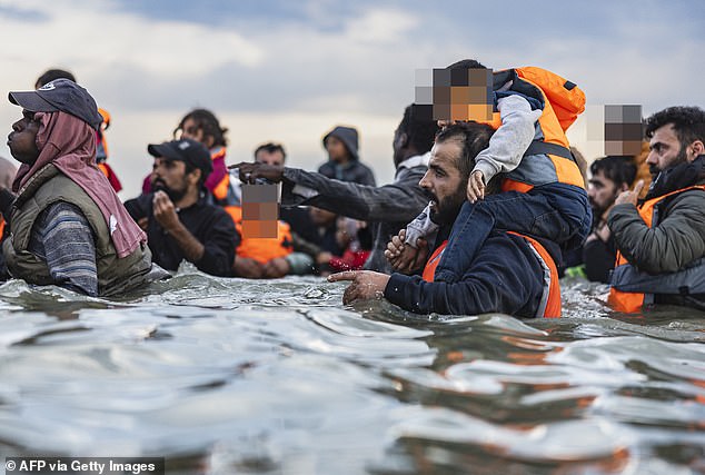 The Home Office this month announced measures to 'crack down' on social media promoting illegal passage from France to the UK. Pictured: Migrants try to board a smuggler's boat to cross the Channel off Gravelines beach in France on August 12, 2025