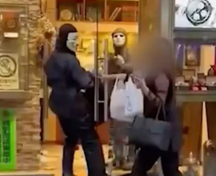 Two masked individuals appear to be robbing a store.