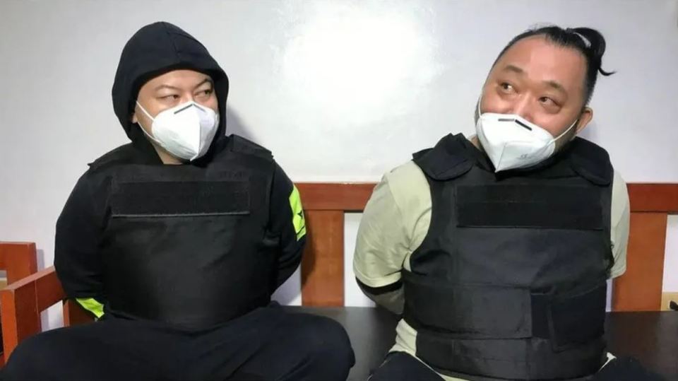 Two men in protective vests and face masks.
