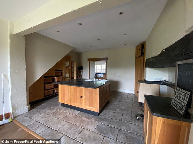The kitchen in the farmhouse with ample cupboard space and an island with a sink and counter