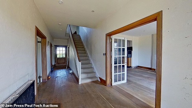 The entrance hallway of the property with a staircase to the first floor and a wide door frame