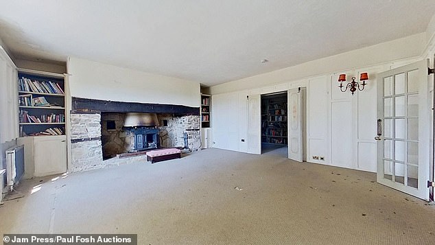 A rustic fireplace  in a spacious sitting room in the property with exposed stonework surrounding it