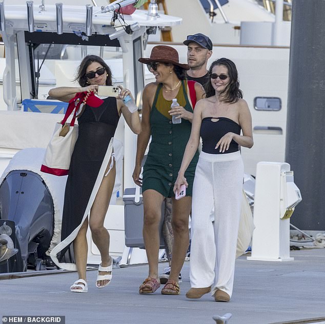 The star paired her one-piece swimsuit with white pants and brown boots. She accessorized with black sunglasses and wore her hair down