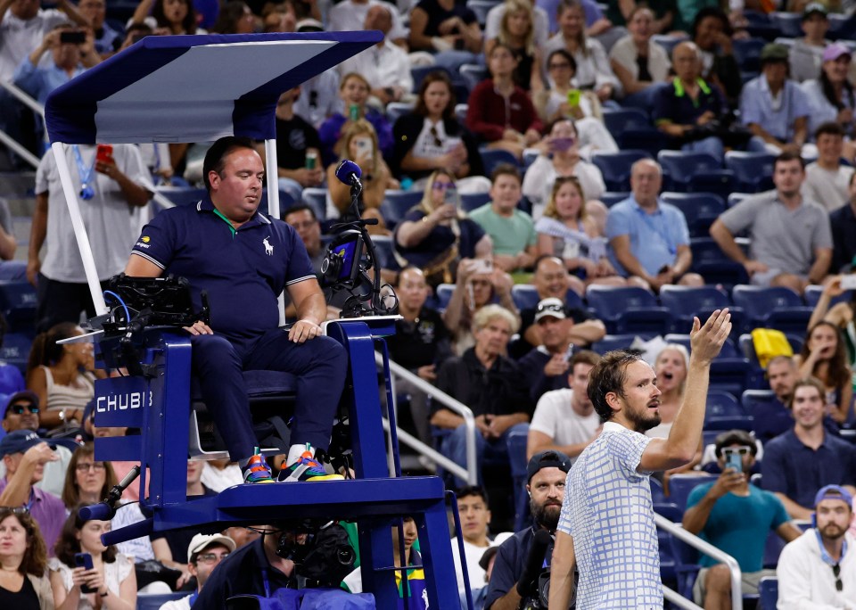Daniil Medvedev speaking to the referee during a tennis match.