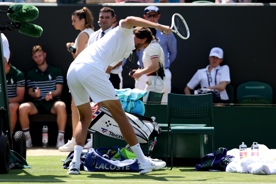Daniil Medvedev throwing his tennis racket after a match.