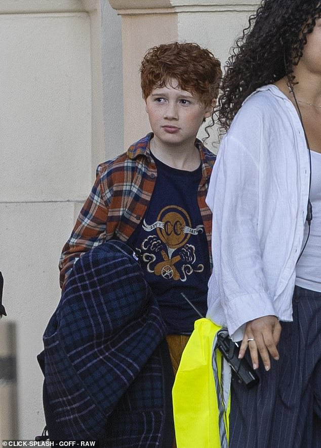 Alistair wore a plaid over shirt which was teamed with corduroy bell bottoms along with a thick duffel coat and school bag for scenes