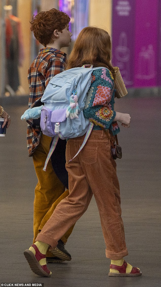 Actress Gracie carried a blue rucksack and sipped on a bejewelled travel cup