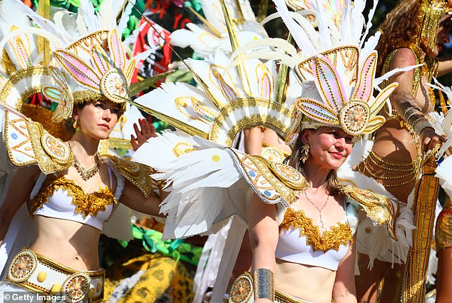 Revellers take part in the Notting Hill Carnival in the sunny conditions in London today