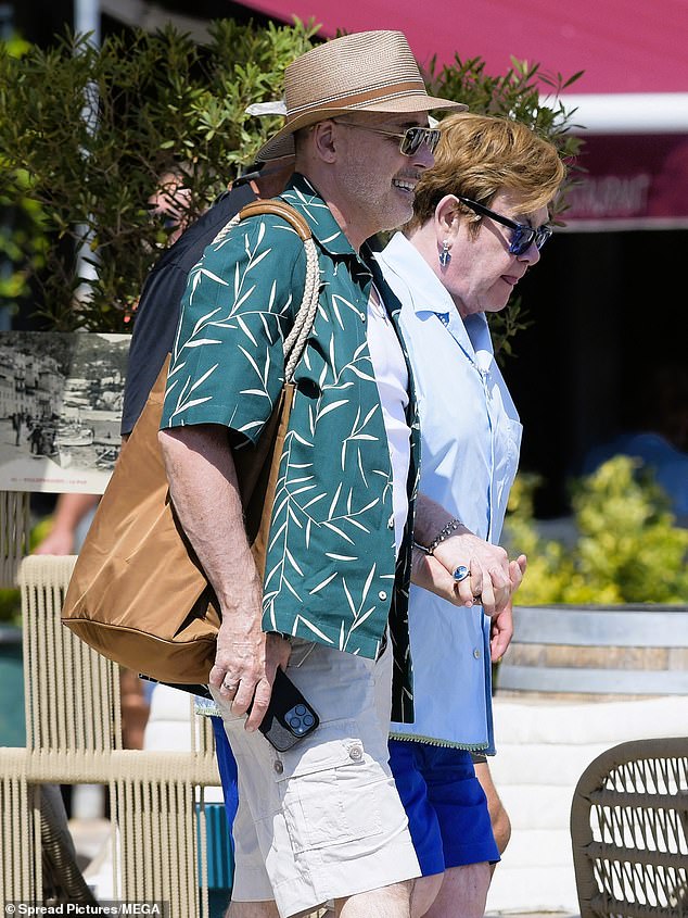 Elton and David sweetly held hands as they departed their lavish yacht together