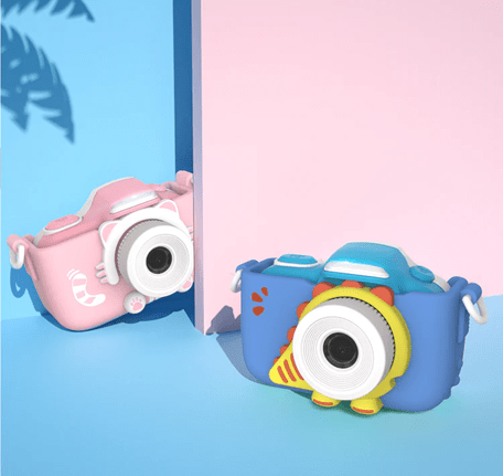 Two children's cameras; one pink with a cat design, one blue with a dinosaur design.