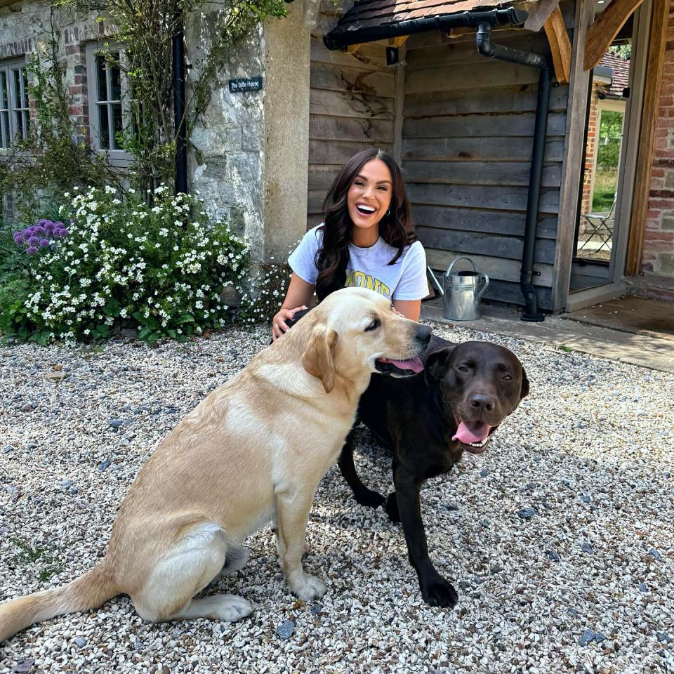 Woman smiling with two Labrador Retrievers.