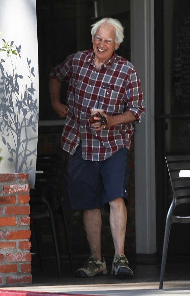 Mark Harmon smiling and holding a drink.