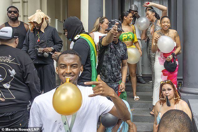 Revellers holding balloons on the second day of Notting Hill Carnival - the world's second biggest celebration after Rio Carnival in Brazil