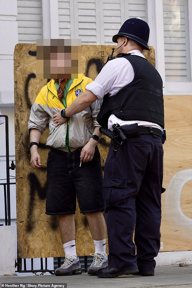 A young man is stopped and searched by the Met Police at Notting Hill Carnival