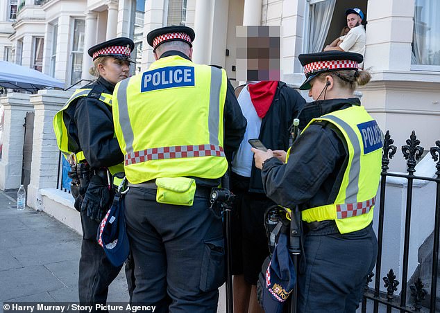 Another young man is pictured surrounded by police on the second day of the carnival