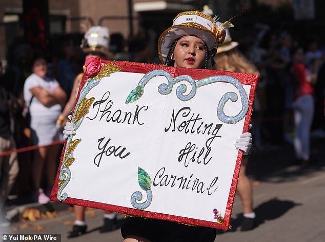 One participant holds up a sign which reads: 'Thank you Notting Hill Carnival'
