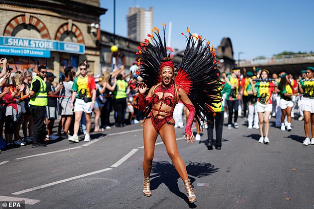 A dancer dressed in red performs during the carnival in Notting Hill today