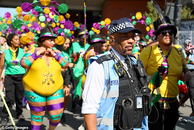 A police officer watches on during the Notting Hill Carnival today in London