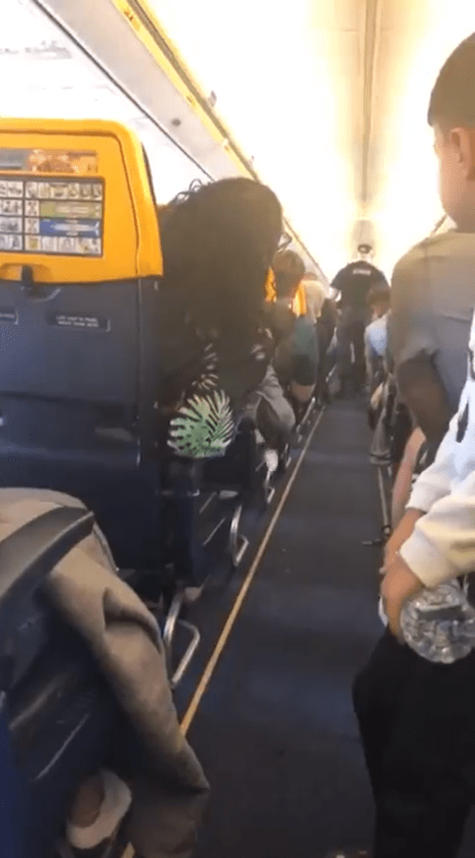 Police officers boarding a Ryanair plane.
