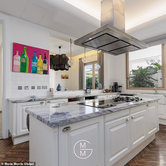 The property's 'state of the art' kitchen features high-end Miele appliances as well as a sleek centre island with grey counter tops